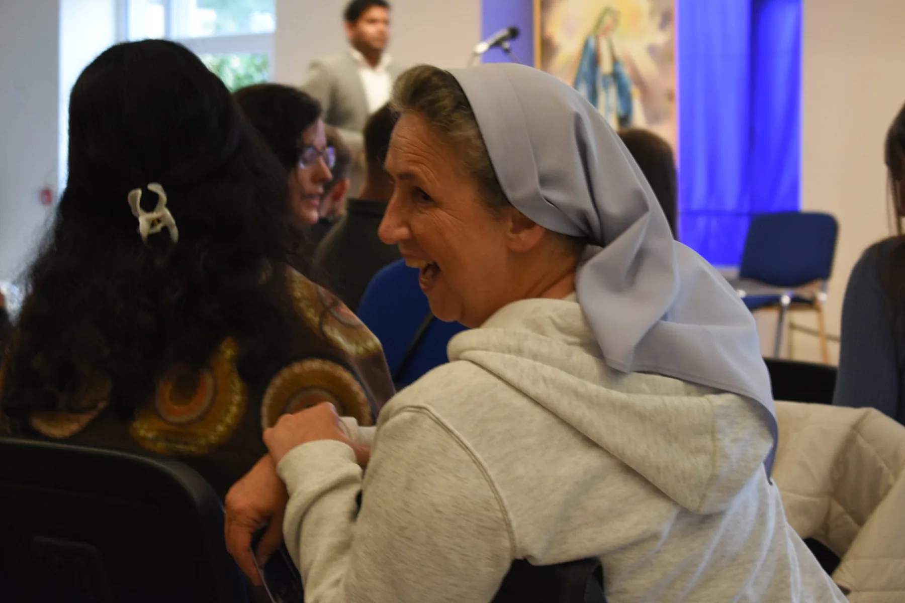 A religious sister and a young woman talking during the break
