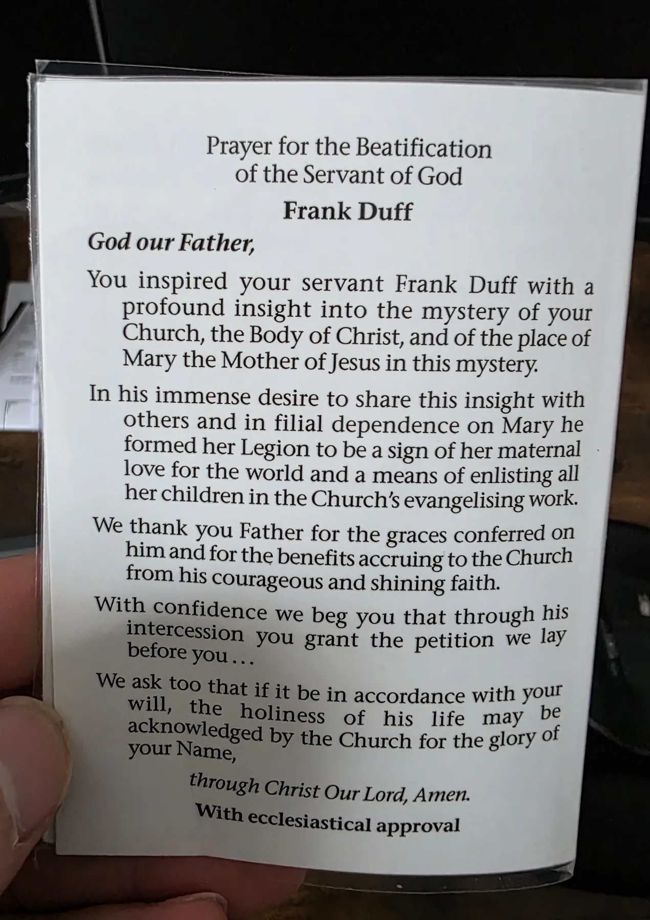 The printed prayer card for the beatification of the Servant of God Frank Duff, held in the hand