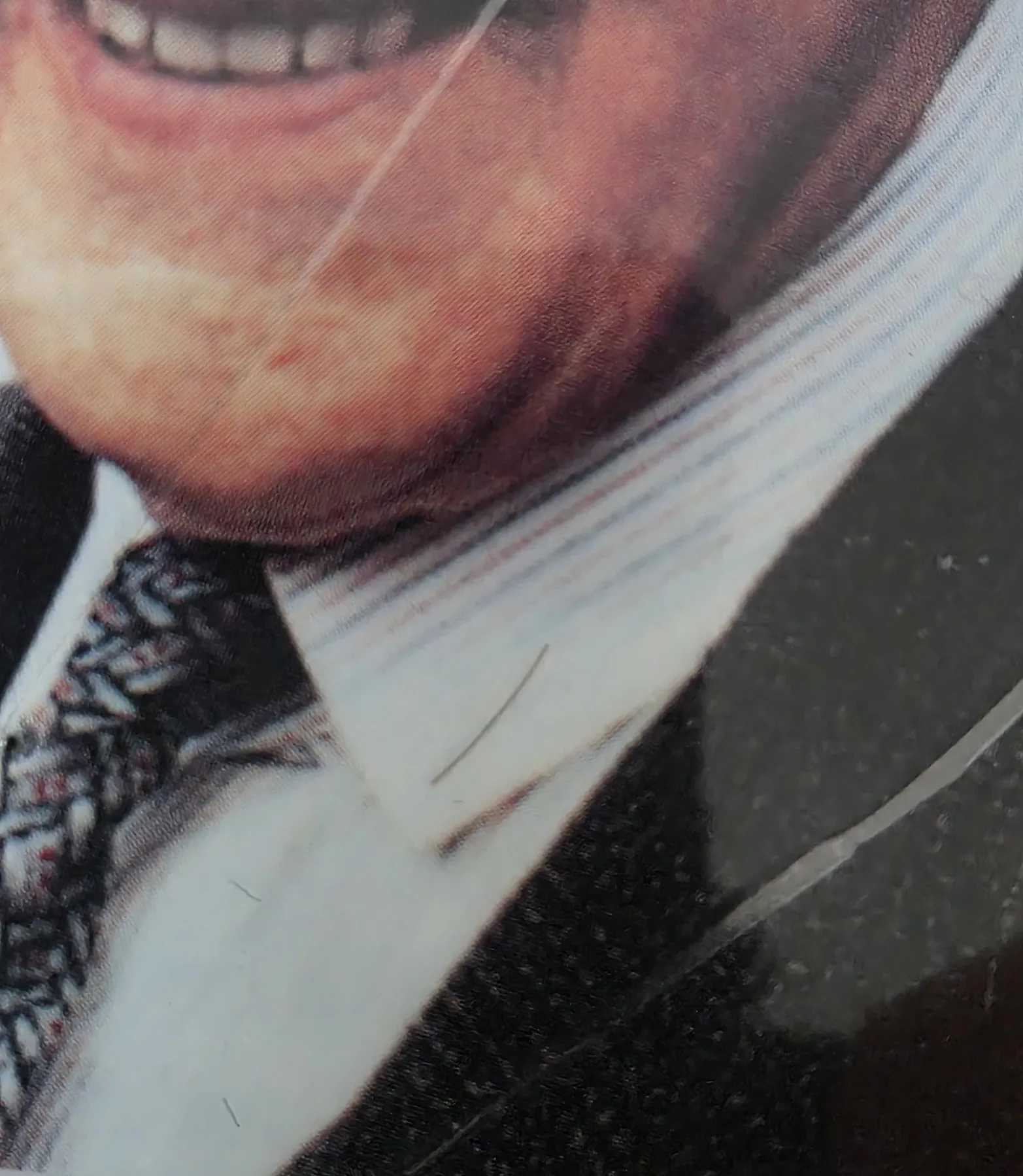 Close detail of the fine strands of hair laid on the shirt in the photograph on the card