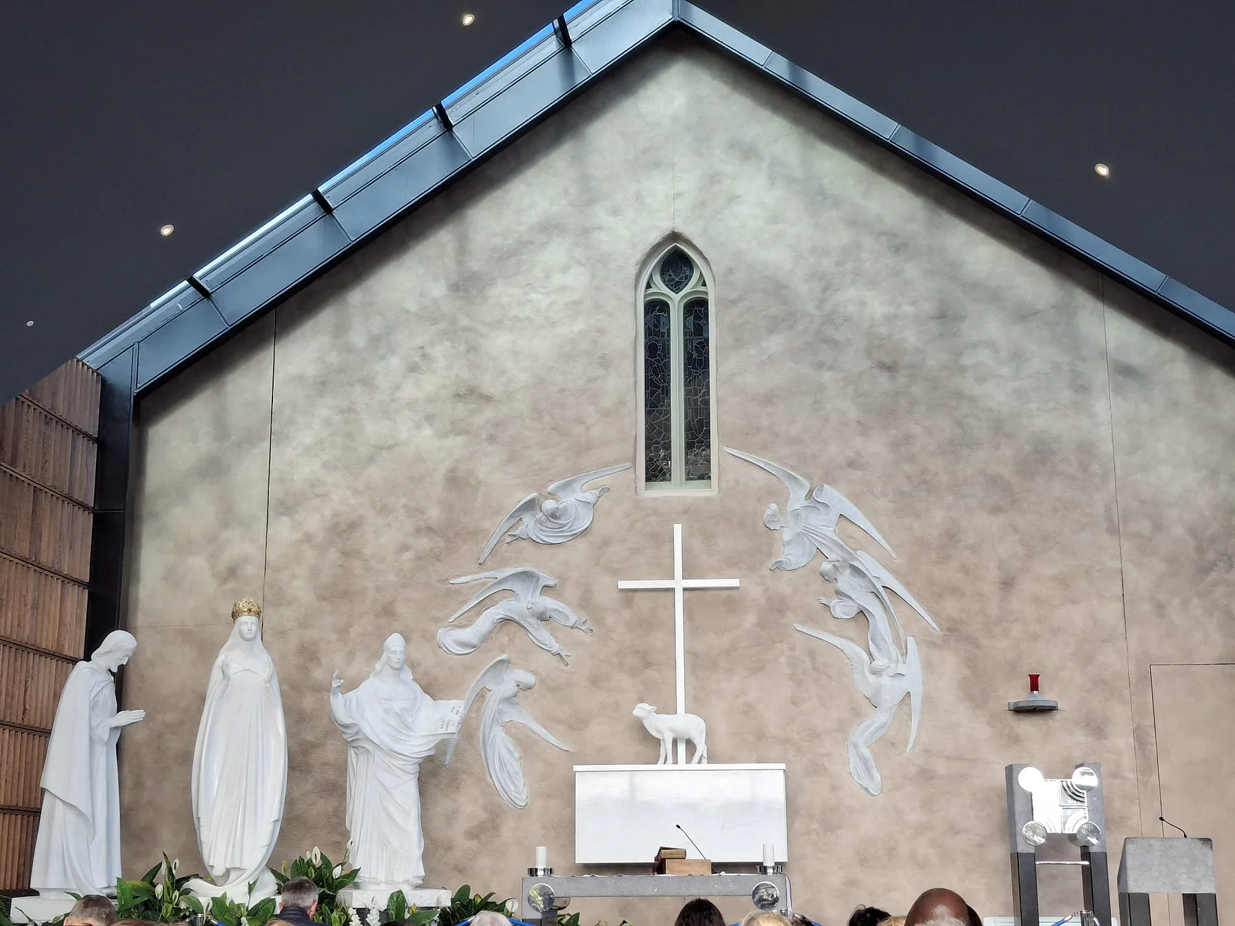 The apparition scene in the Apparition Chapel: Our Lady, St Joseph and St John the Evangelist in white, with the Lamb on the altar before the cross