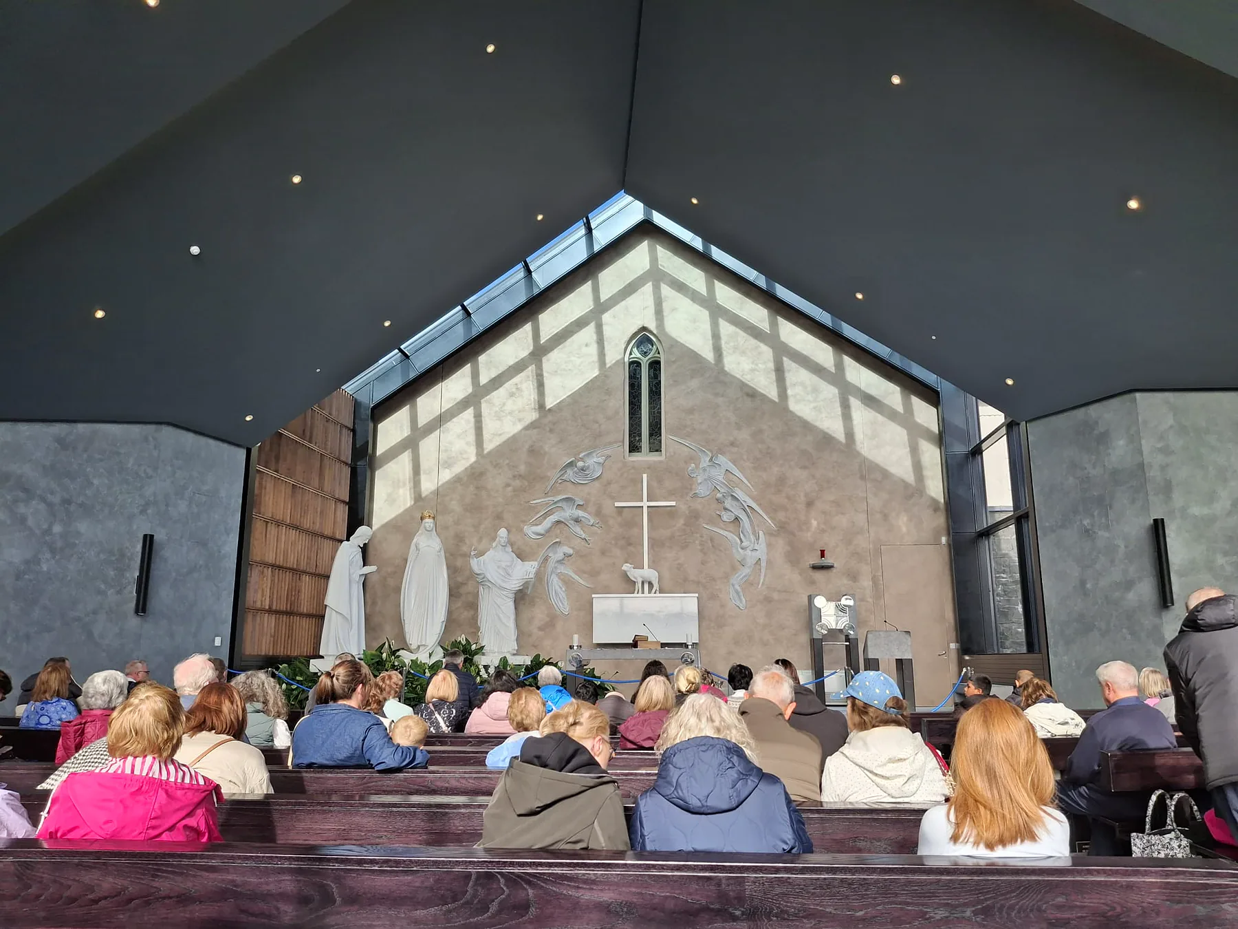 Pilgrims at prayer in the Apparition Chapel before the gable wall