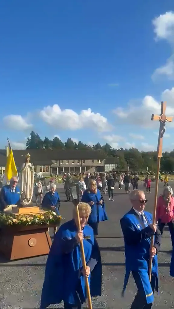 Our Lady&rsquo;s statue carried in procession through the shrine grounds, with the Legion banners and the clergy following