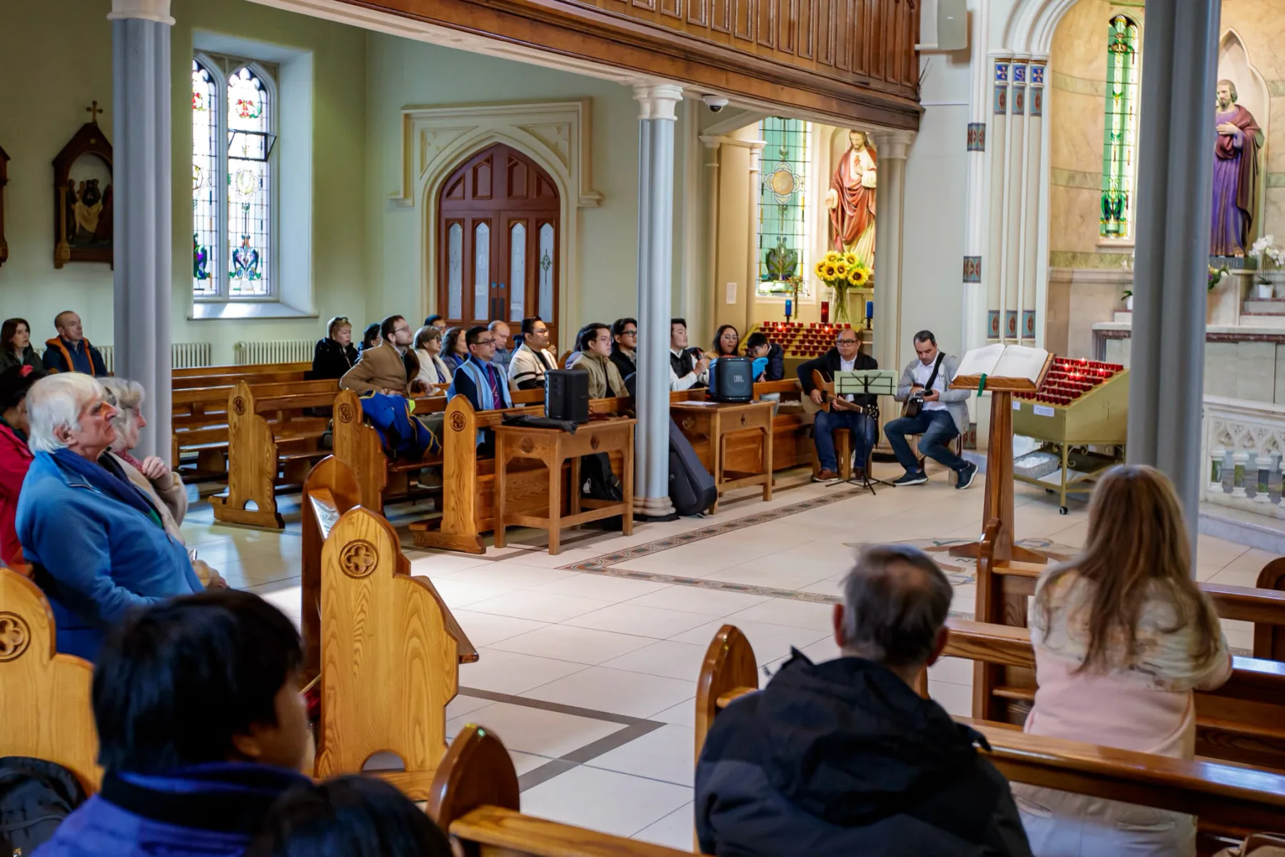 Musicians leading the singing beside the sanctuary, with the congregation in the pews