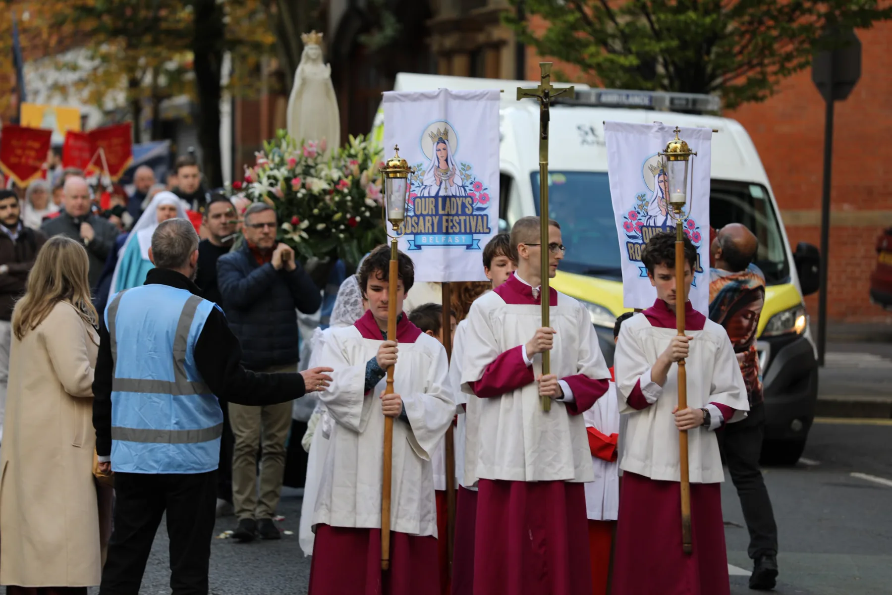 Altar servers with processional candles and the festival banners, Our Lady&rsquo;s statue following behind