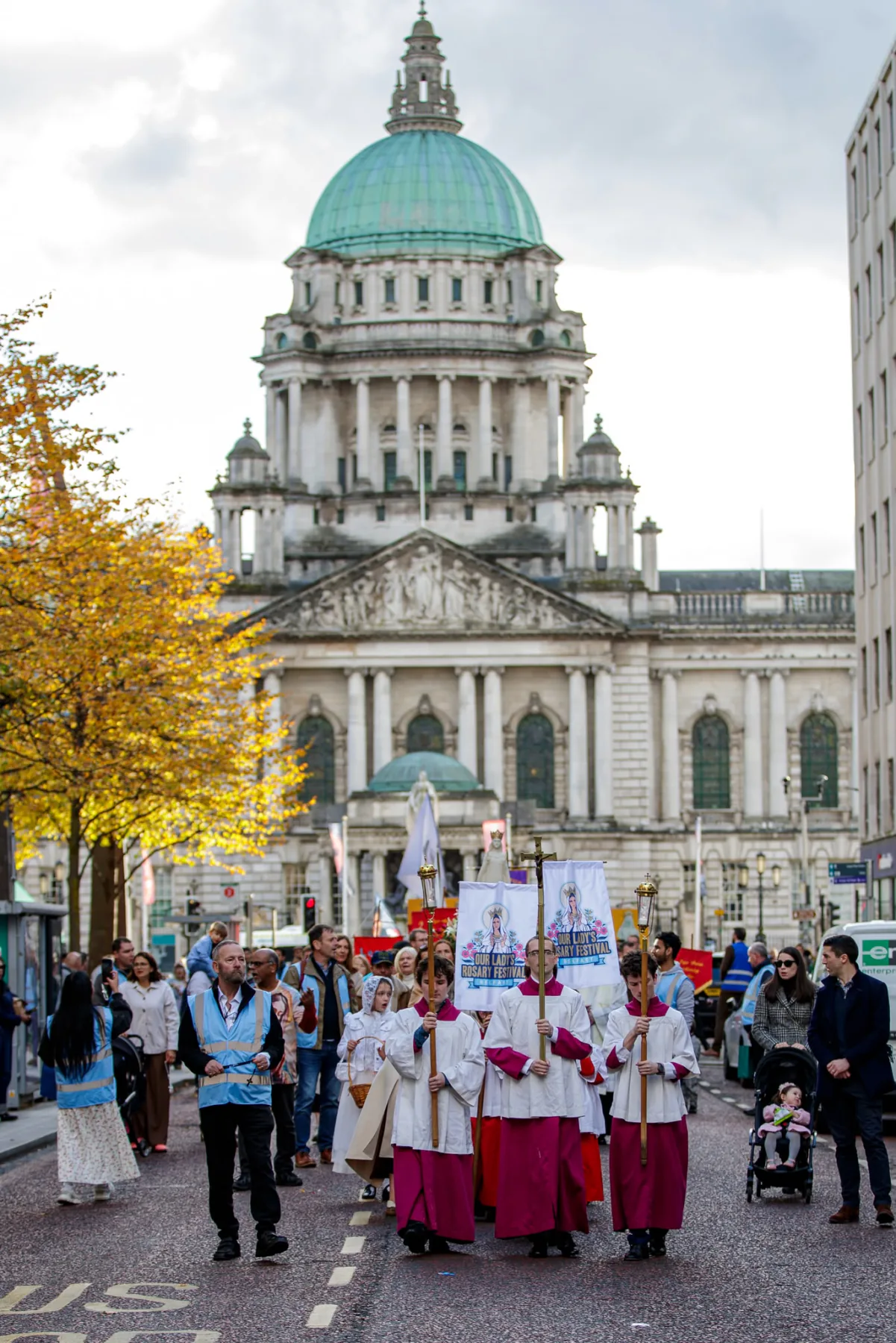 The procession passing Belfast City Hall for the first time, the altar servers and banners at its head